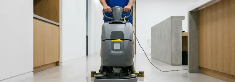 Janitorial staff using a floor scrubber machine to clean a commercial hallway, Fort Collins, CO.