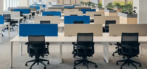 Modern open-plan office space featuring clean workstations, ergonomic chairs, and sanitized carpets provided by professional office cleaning services in Fort Collins, CO.